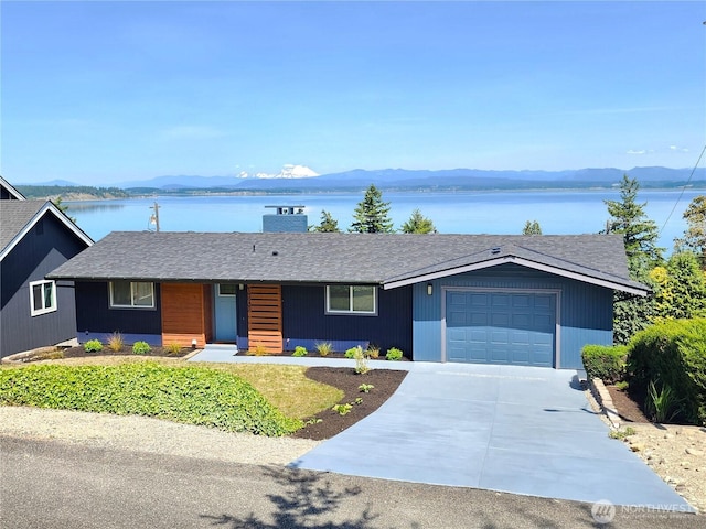 1345 Rainbow Ln, Camano Island, WA 98282 - ranch-style home featuring a garage, concrete driveway, and a water and mountain view