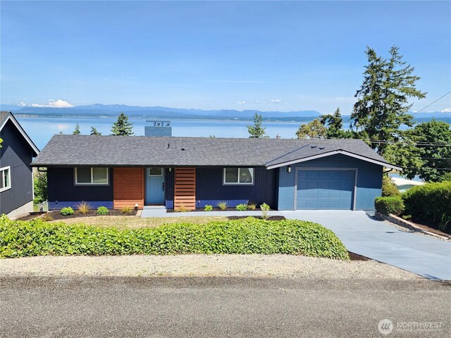 1345 Rainbow Ln, Camano Island, WA 98282 - single story home with an attached garage, concrete driveway, roof with shingles, and a water view