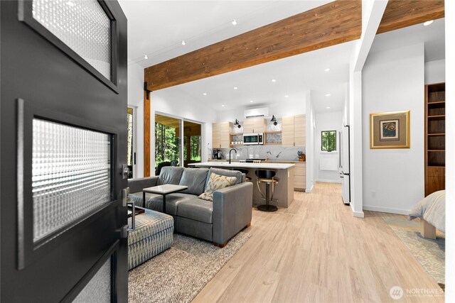 19 Davelaar Dr, Mazama, WA 98833 - living area with light wood finished floors, plenty of natural light, beam ceiling, recessed lighting, and a wall unit AC