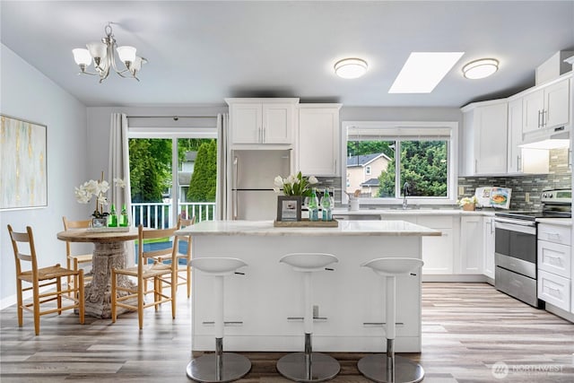 2 199th Pl SE, Bothell, WA 98012 - kitchen featuring appliances with stainless steel finishes, a skylight, healthy amount of natural light, and backsplash
