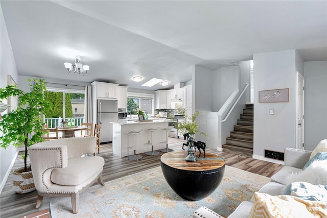 2 199th Pl SE, Bothell, WA 98012 - living room featuring stairway, light wood-style floors, a chandelier, baseboards, and vaulted ceiling