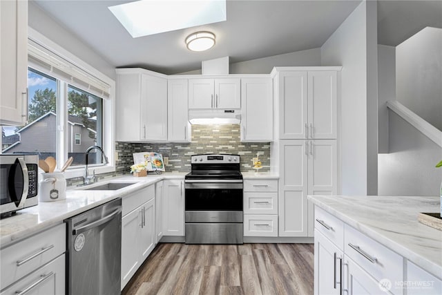 2 199th Pl SE, Bothell, WA 98012 - kitchen featuring appliances with stainless steel finishes, a sink, a skylight, under cabinet range hood, and tasteful backsplash