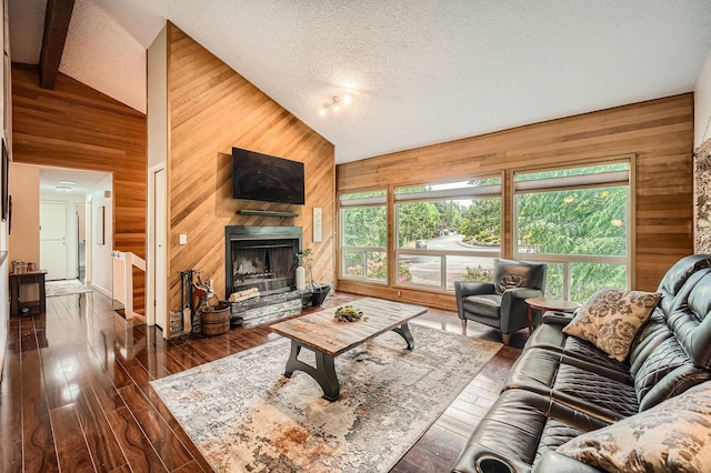 2617 35th Ave SE, Puyallup, WA 98374 - living room featuring wood walls, a fireplace with raised hearth, dark wood-type flooring, and a textured ceiling