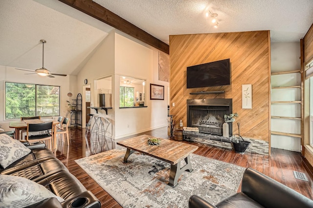 2617 35th Ave SE, Puyallup, WA 98374 - living area with wood finished floors, wooden walls, ceiling fan, a fireplace with raised hearth, and a textured ceiling