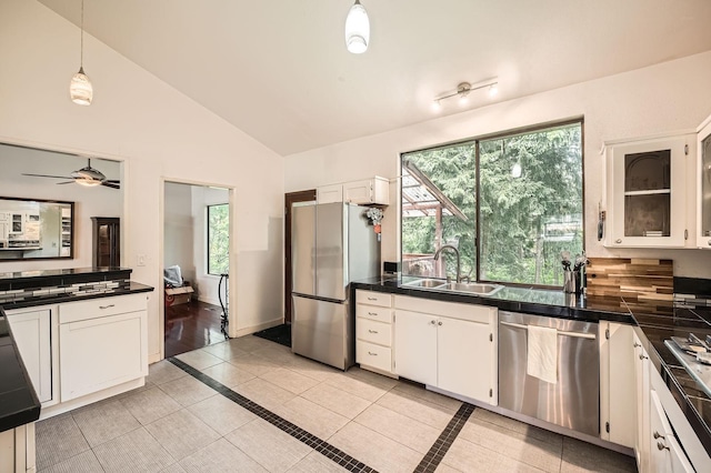 2617 35th Ave SE, Puyallup, WA 98374 - kitchen featuring appliances with stainless steel finishes, a sink, dark countertops, white cabinetry, and vaulted ceiling