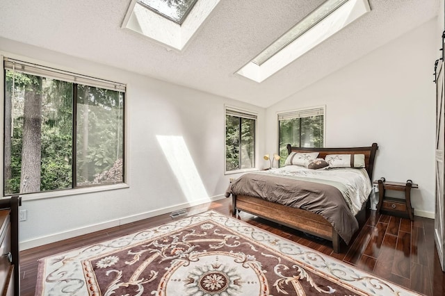 2617 35th Ave SE, Puyallup, WA 98374 - bedroom featuring a skylight, wood finished floors, baseboards, lofted ceiling, and a textured ceiling