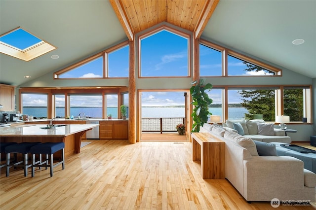 2778 N Nugent Rd N, Lummi Island, WA 98262 - living area with a water view, a skylight, light wood-style flooring, and high vaulted ceiling