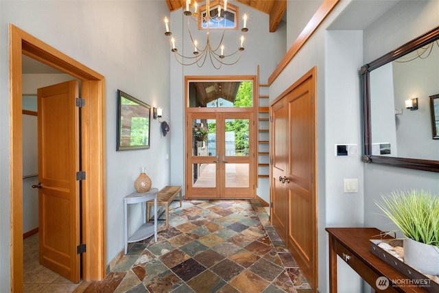 2778 N Nugent Rd N, Lummi Island, WA 98262 - foyer entrance featuring dark stone finish floors, a chandelier, high vaulted ceiling, baseboards, and french doors