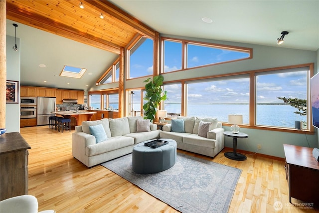 2778 N Nugent Rd N, Lummi Island, WA 98262 - living room featuring a water view, healthy amount of natural light, beam ceiling, light wood-type flooring, and high vaulted ceiling