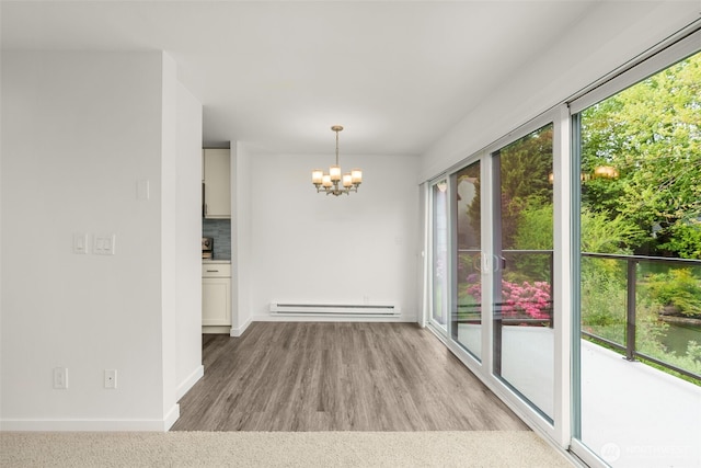 19414 Aurora Ave N Unit 204, Shoreline, WA 98133 - unfurnished dining area featuring a baseboard radiator, a chandelier, wood finished floors, and baseboards