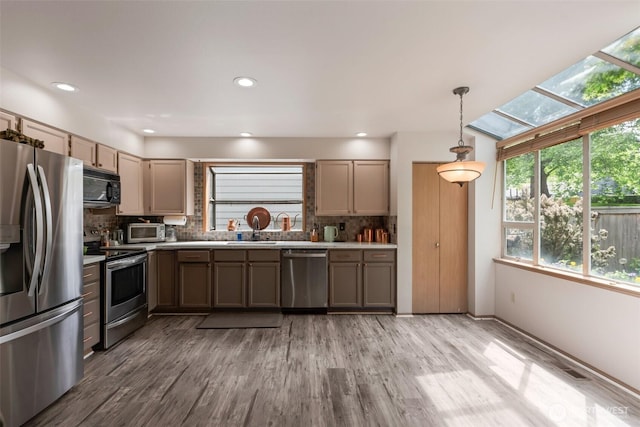 707 S 32nd, Renton, WA 98055 - kitchen featuring appliances with stainless steel finishes, backsplash, light countertops, light wood-type flooring, and recessed lighting