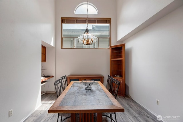 707 S 32nd, Renton, WA 98055 - dining space with a chandelier, wood finished floors, a towering ceiling, and baseboards