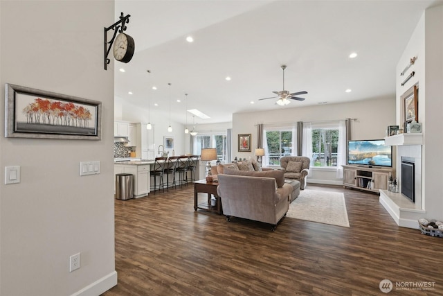 1172 Matterhorn Loop, Camano Island, WA 98282 - living area with a ceiling fan, dark wood-style flooring, recessed lighting, a glass covered fireplace, and baseboards