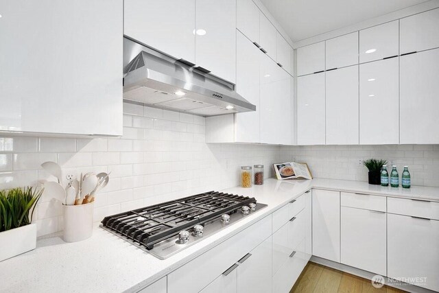 14144 270th Ln NE, Duvall, WA 98019 - kitchen featuring stainless steel gas stovetop, exhaust hood, light countertops, and white cabinets