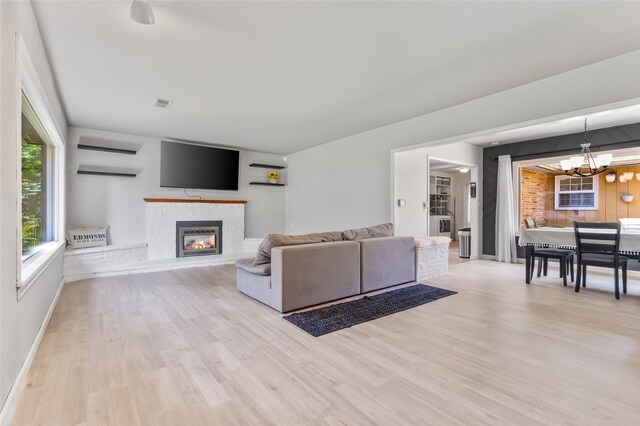7715 236th St SW, Edmonds, WA 98026 - living room featuring wood finished floors, a chandelier, a glass covered fireplace, and baseboards