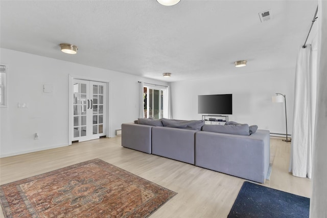 7715 236th St SW, Edmonds, WA 98026 - living area with wood finished floors, baseboard heating, and french doors