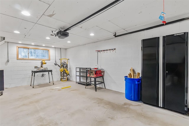 7715 236th St SW, Edmonds, WA 98026 - garage with a garage door opener, freestanding refrigerator, and concrete block wall