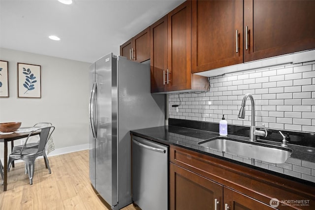 21301 48th Ave W Unit A104, Mountlake Terrace, WA 98043 - kitchen with stainless steel appliances, a sink, dark stone counters, decorative backsplash, and light wood-style floors
