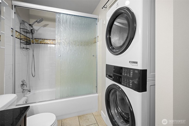 21301 48th Ave W Unit A104, Mountlake Terrace, WA 98043 - bathroom featuring stacked washing machine and dryer, toilet, shower / bath combination with glass door, vanity, and tile patterned floors