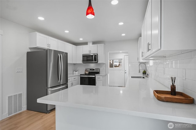 3514 S Tyler St, Tacoma, WA 98409 - kitchen with appliances with stainless steel finishes, a sink, a peninsula, backsplash, and light countertops