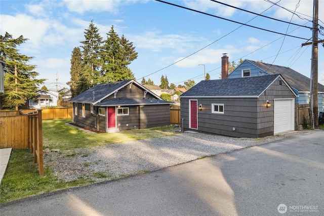 3514 S Tyler St, Tacoma, WA 98409 - view of front of home with a shingled roof, an outbuilding, a detached garage, a chimney, and driveway