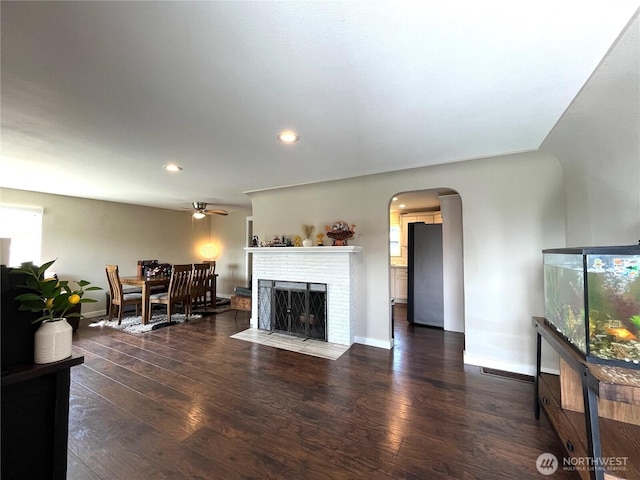 6612 E B St, Tacoma, WA 98404 - living area featuring wood finished floors, arched walkways, a fireplace, ceiling fan, and recessed lighting
