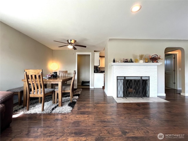 6612 E B St, Tacoma, WA 98404 - dining space with ceiling fan, arched walkways, a brick fireplace, wood finished floors, and baseboards
