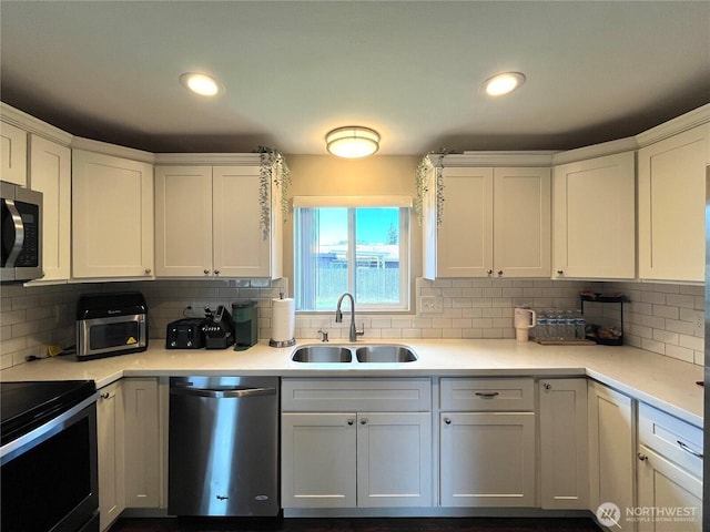 6612 E B St, Tacoma, WA 98404 - kitchen featuring appliances with stainless steel finishes, a sink, white cabinetry, tasteful backsplash, and recessed lighting
