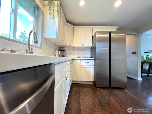 6612 E B St, Tacoma, WA 98404 - kitchen featuring freestanding refrigerator, dark wood finished floors, light countertops, arched walkways, and tasteful backsplash