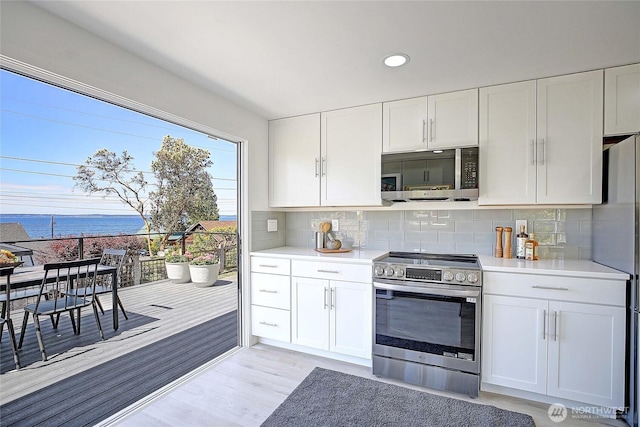275 Maple St, Camano Island, WA 98282 - kitchen with stainless steel appliances, light countertops, white cabinetry, decorative backsplash, and recessed lighting