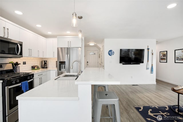 817 Kitsap St, Port Orchard, WA 98366 - kitchen with stainless steel appliances, a center island with sink, tasteful backsplash, baseboards, and a sink