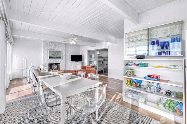 7491 Birch Bay Dr, Blaine, WA 98230 - dining room featuring wood finished floors, a ceiling fan, a fireplace, and wooden ceiling with exposed beams