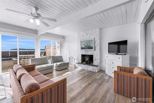 7491 Birch Bay Dr, Blaine, WA 98230 - living area featuring ceiling fan, wood finished floors, a stone fireplace, and wood ceiling with exposed beams