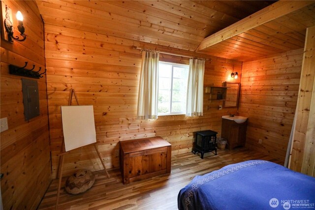 54 Center View Dr, Decatur Island, WA 98221 - bedroom with a wood stove, wood finished floors, wood walls, electric panel, and wooden ceiling