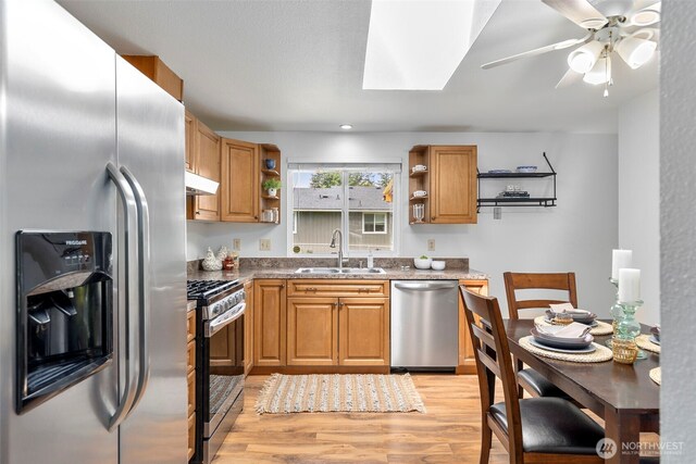 7475 Trica Ave, Bremerton, WA 98311 - kitchen featuring stainless steel appliances, a sink, open shelves, a skylight, and light wood-type flooring
