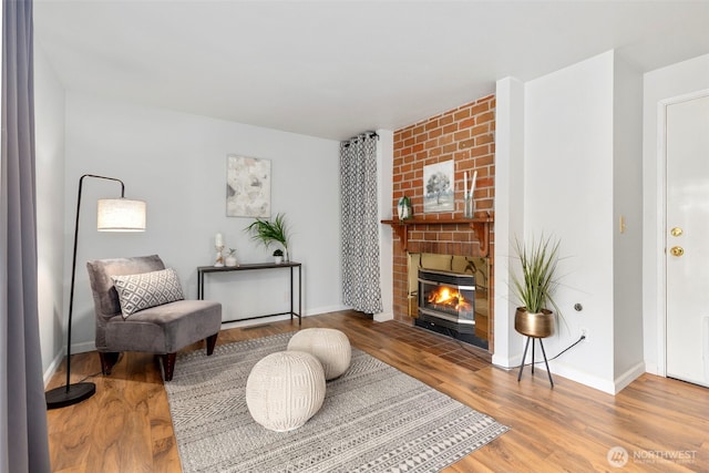 7475 Trica Ave, Bremerton, WA 98311 - living area featuring a brick fireplace, wood finished floors, and baseboards