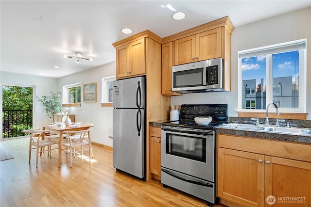 6348 34th Ave SW Unit C, Seattle, WA 98126 - kitchen featuring stainless steel appliances, a sink, dark countertops, light wood-style floors, and recessed lighting