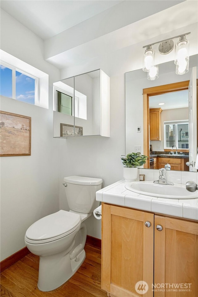 6348 34th Ave SW Unit C, Seattle, WA 98126 - bathroom featuring wood finished floors, toilet, vanity, and baseboards