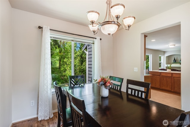 11710 SE 310th St, Auburn, WA 98092 - dining room featuring healthy amount of natural light, a chandelier, light wood finished floors, and baseboards