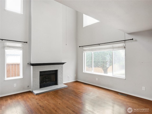 1015 SW 348th Pl, Federal Way, WA 98023 - unfurnished living room with a towering ceiling, wood finished floors, baseboards, and a fireplace