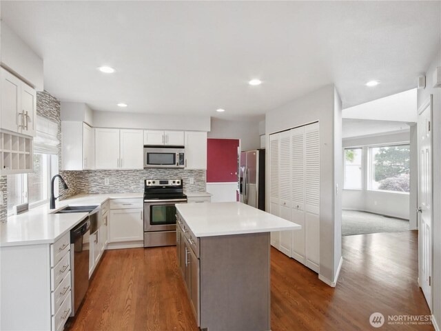 1015 SW 348th Pl, Federal Way, WA 98023 - kitchen with stainless steel appliances, a sink, dark wood-type flooring, decorative backsplash, and light countertops