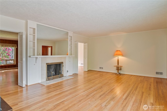 1515 19th Ave, Longview, WA 98632 - unfurnished living room featuring a textured ceiling, wood finished floors, a fireplace, built in shelves, and baseboards