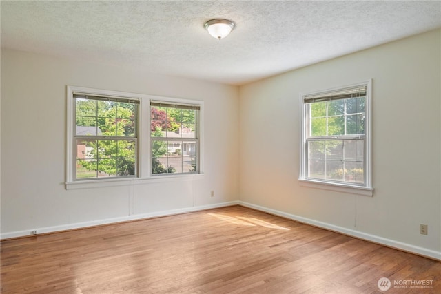 1515 19th Ave, Longview, WA 98632 - spare room featuring wood finished floors, plenty of natural light, a textured ceiling, and baseboards