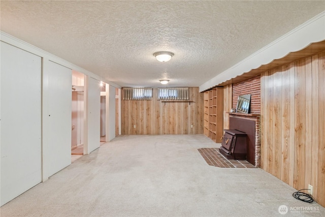 1515 19th Ave, Longview, WA 98632 - unfurnished living room with a wood stove, wooden walls, carpet floors, and a textured ceiling