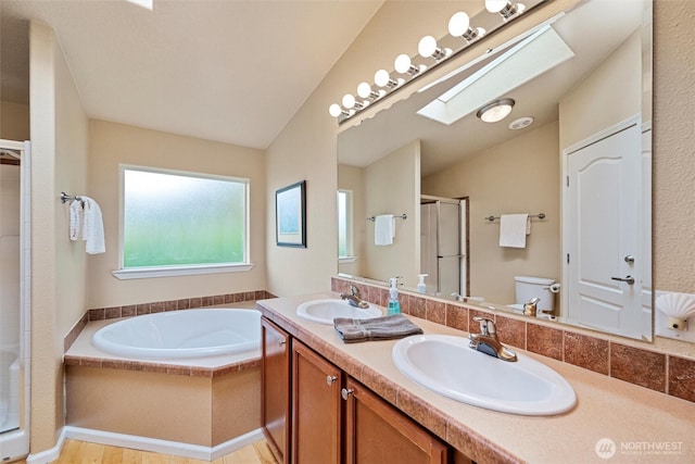 2570 Island View Ln, Lummi Island, WA 98262 - bathroom with a skylight, a shower stall, a garden tub, double vanity, and vaulted ceiling