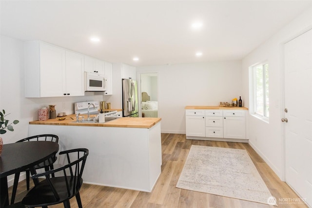 3333 228th St Unit 42, Bothell, WA 98021 - kitchen with butcher block counters, stainless steel fridge with ice dispenser, white microwave, a sink, and light wood finished floors