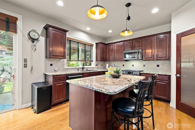 12153 SE 307th Pl, Auburn, WA 98092 - kitchen with dishwashing machine, stainless steel microwave, a sink, light wood-type flooring, and decorative light fixtures