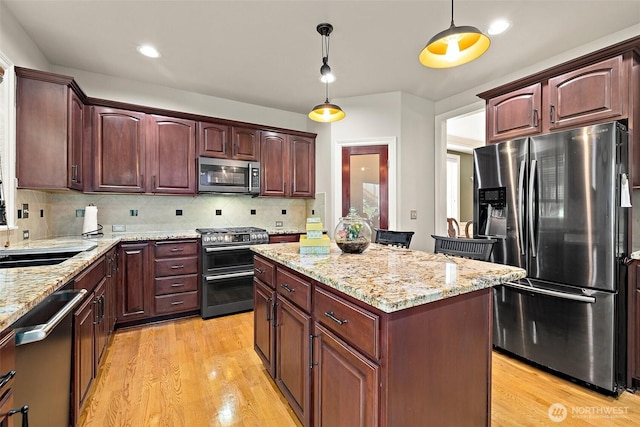 12153 SE 307th Pl, Auburn, WA 98092 - kitchen with stainless steel appliances, a center island, hanging light fixtures, light wood-style floors, and recessed lighting