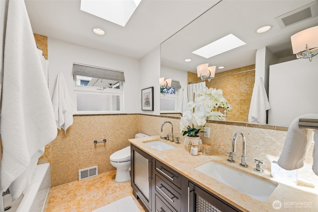 1309 NW Norcross Way, Seattle, WA 98177 - bathroom with a skylight, tile walls, toilet, double vanity, and tiled shower