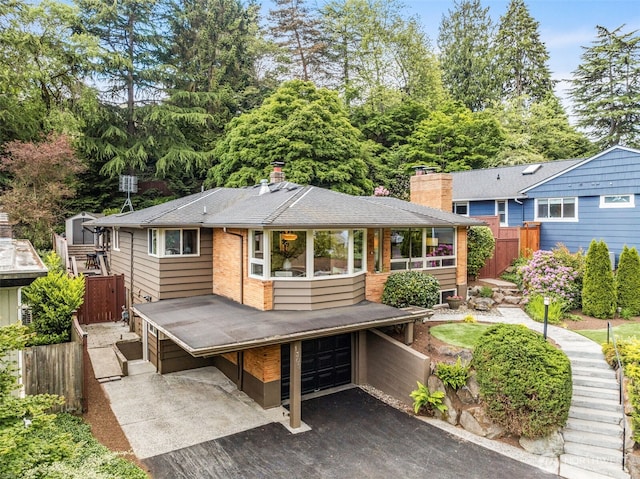 1309 NW Norcross Way, Seattle, WA 98177 - back of house with driveway, a garage, a chimney, and roof with shingles